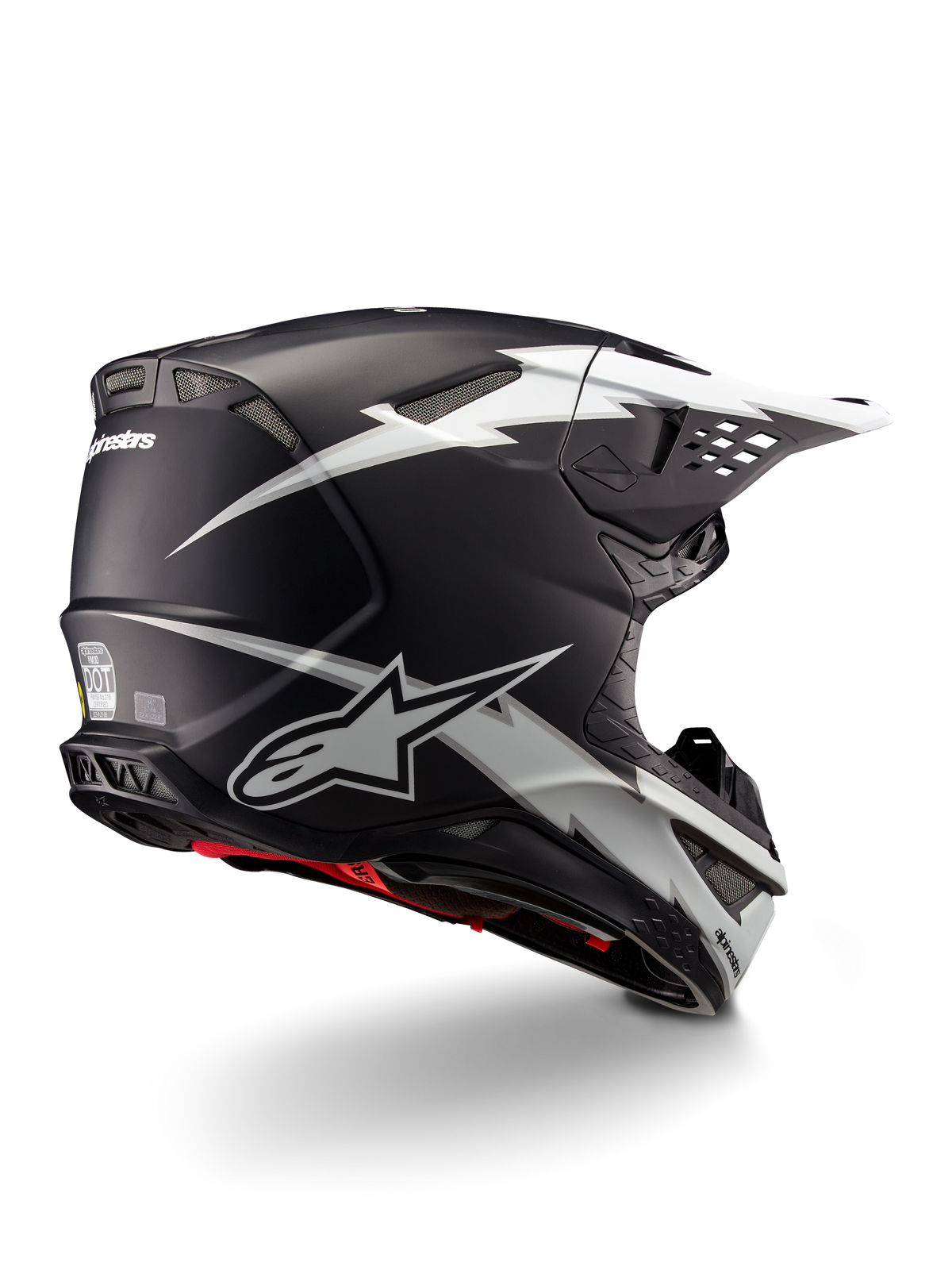 Casco Alpinestars Supertech M10 Ampress, casco da motocross, nero e bianco opaco, con grafiche a fulmini bianchi su calotta nera opaca, vista posteriore a tre quarti che mostra il logo Alpinestars e le prese d'aria