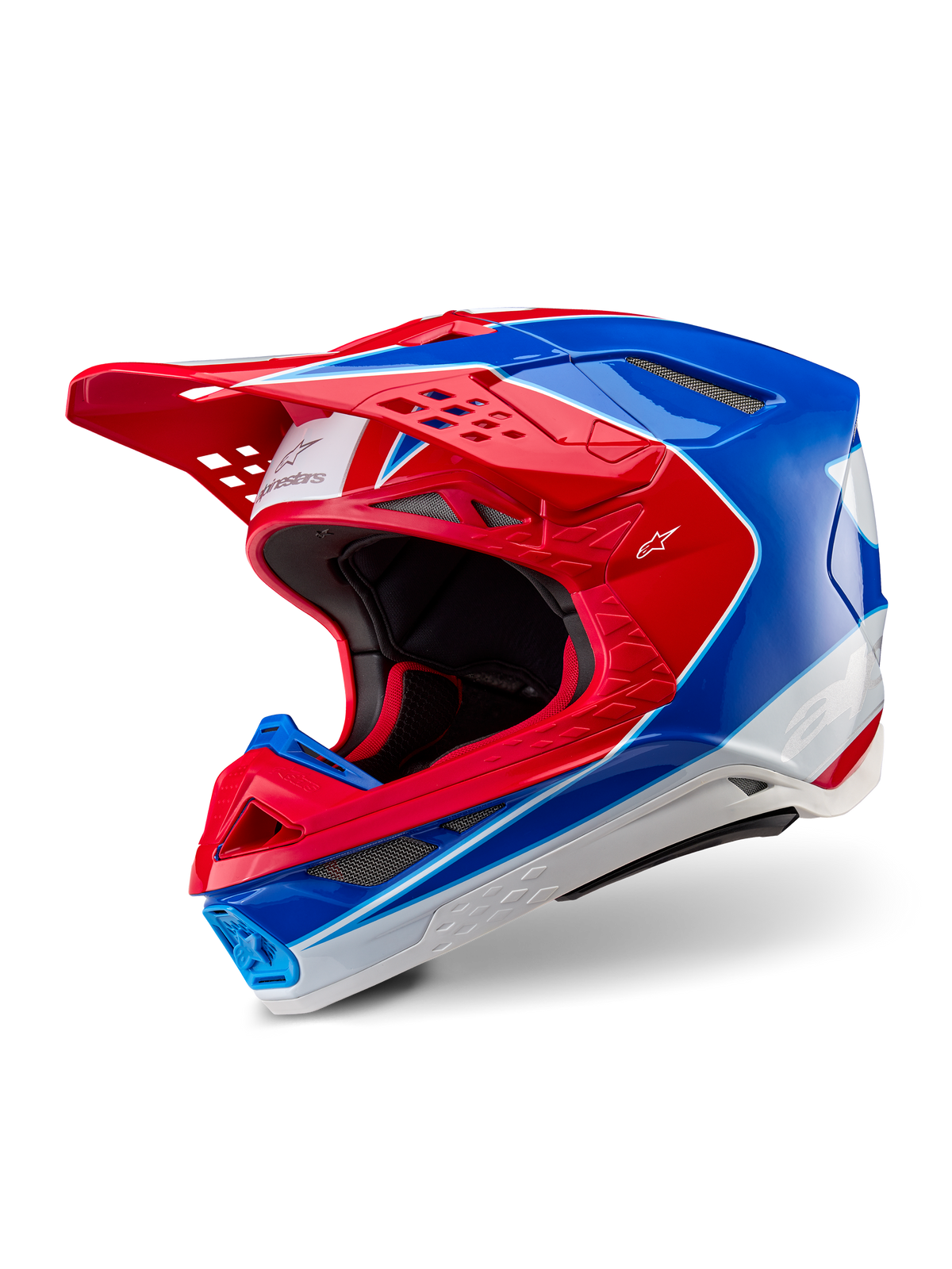 Casco Alpinestars Supertech M10 Aeon, casco da motocross, rosso e blu lucido, vista a tre quarti che mostra la calotta aerodinamica con prese d'aria multiple, accenti grafici bianchi e rossi, logo Alpinestars sulla visiera e sul lato, equipaggiamento professionale per gare fuoristrada