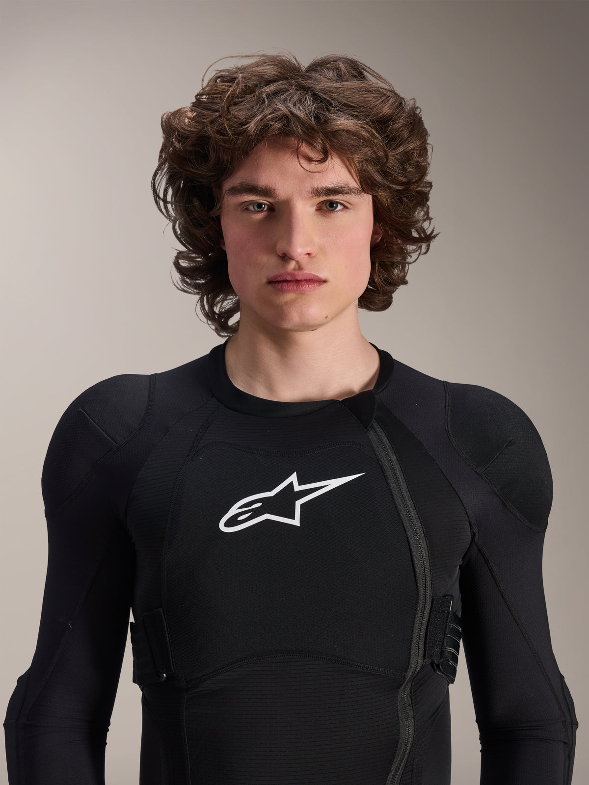 Modello uomo che indossa la Giacca protettiva Alpinestars A-Impact Plasma a maniche lunghe, nera con logo Astars bianco, dotata di cerniera frontale asimmetrica e imbottiture integrate, protezione professionale per MTB