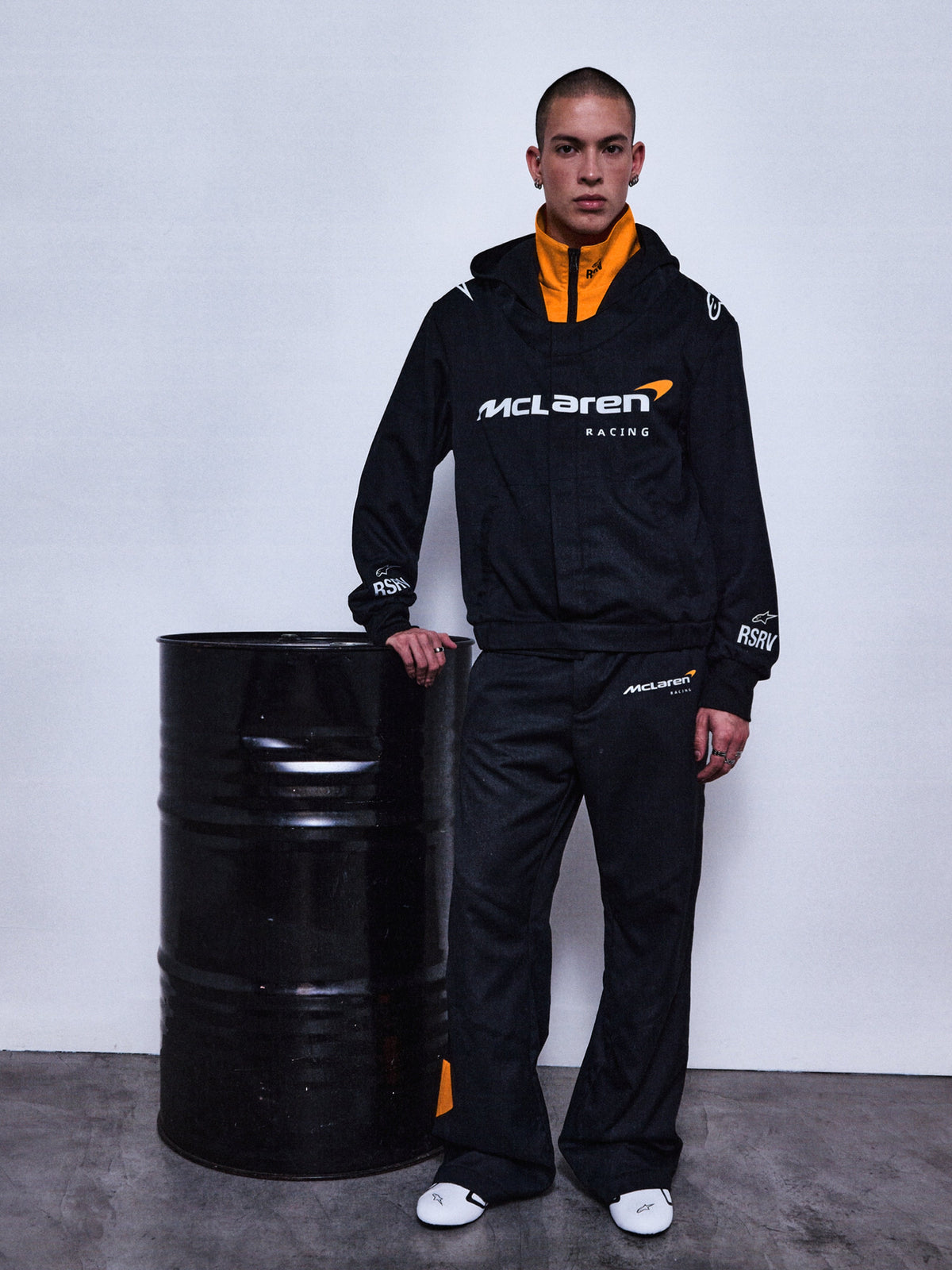 Alpinestars RSRV Arena Suit Jacket, giacca collaborazione McLaren Racing, nera con fodera arancione, logo McLaren Racing bianco, abbigliamento sportivo premium