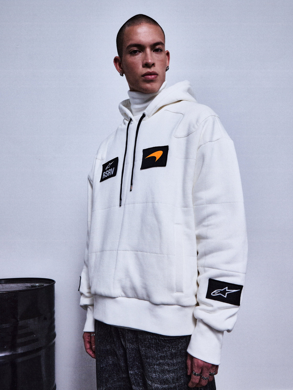 Alpinestars RSRV Rival Hoodie, felpa bianca con toppe nere, patch arancione, collo alto, abbigliamento streetwear premium, stile urbano