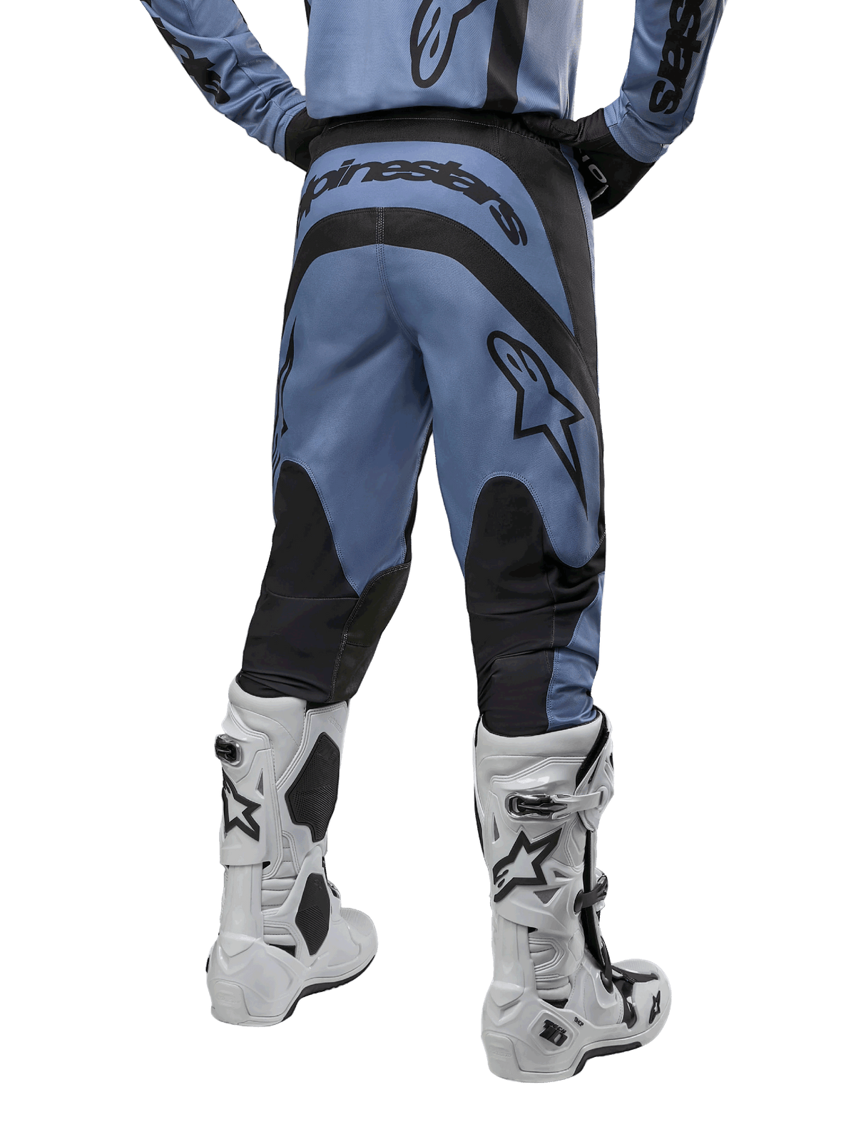Alpinestars 2024 Fluid Lurv Pants, pantaloni da motocross, azzurro e nero, vista posteriore che mostra pannelli rinforzati neri e un grande logo del marchio, abbinati a stivali da motocross bianchi e neri, equipaggiamento professionale per fuoristrada