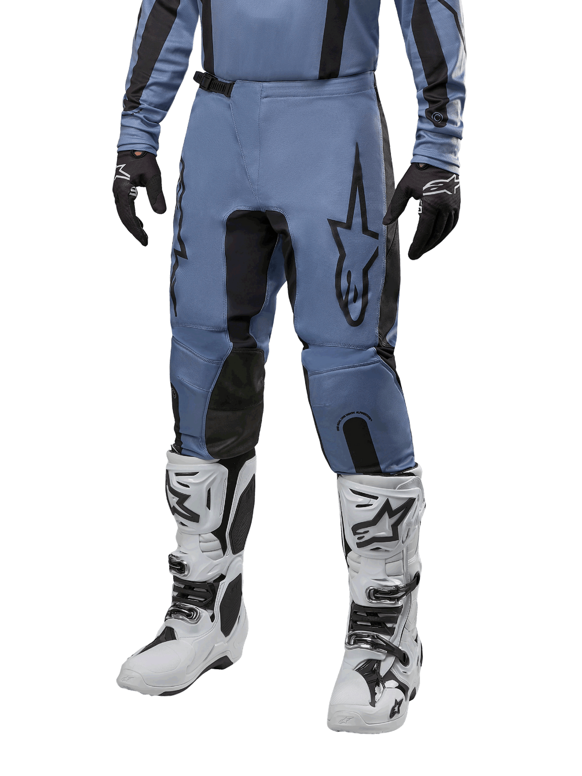 Pantaloni Alpinestars Fluid Lurv 2024, pantaloni da motocross blu chiaro e nero, indossati con maglia a maniche lunghe coordinata e stivali da motocross bianchi, caratterizzati da un evidente logo a stella nero sulla coscia e pannelli interni rinforzati sulle ginocchia, vista frontale su sfondo bianco.