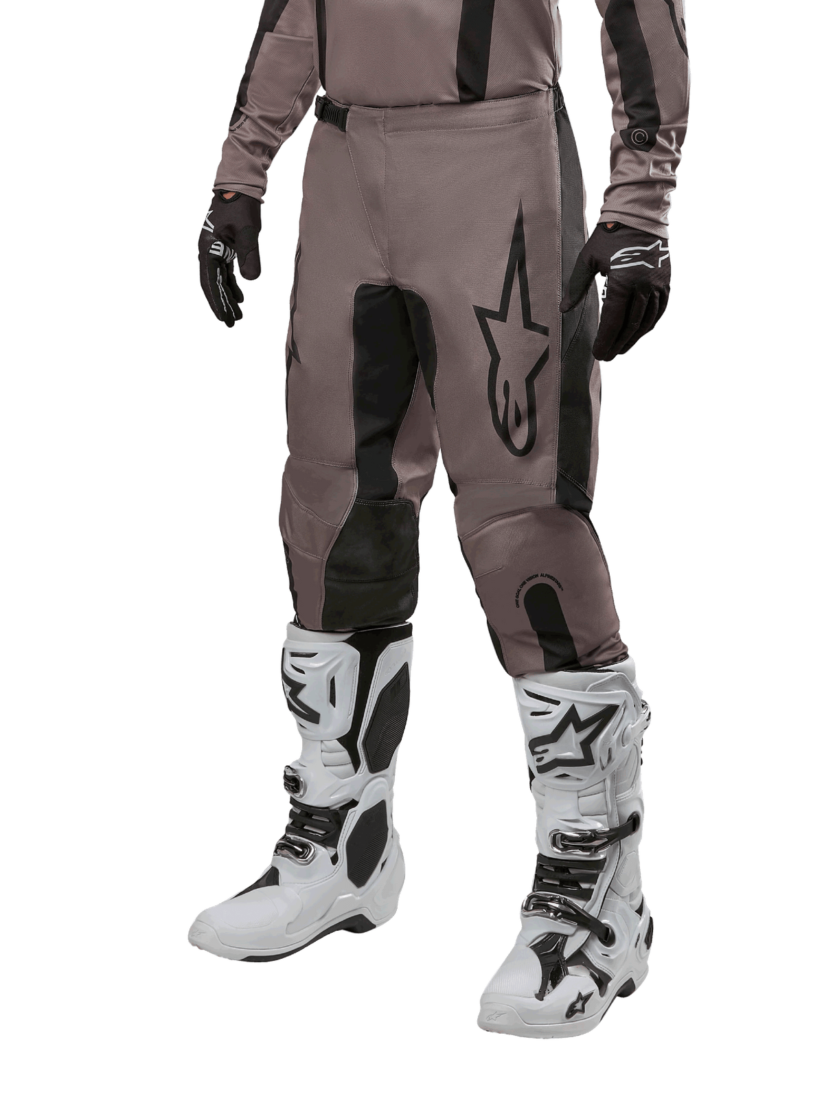 Alpinestars 2024 Fluid Lurv Pants, pantaloni da motocross, fango e nero, con logo Alpinestars, indossati con guanti neri e stivali da motocross bianchi, design sportivo per gare fuoristrada