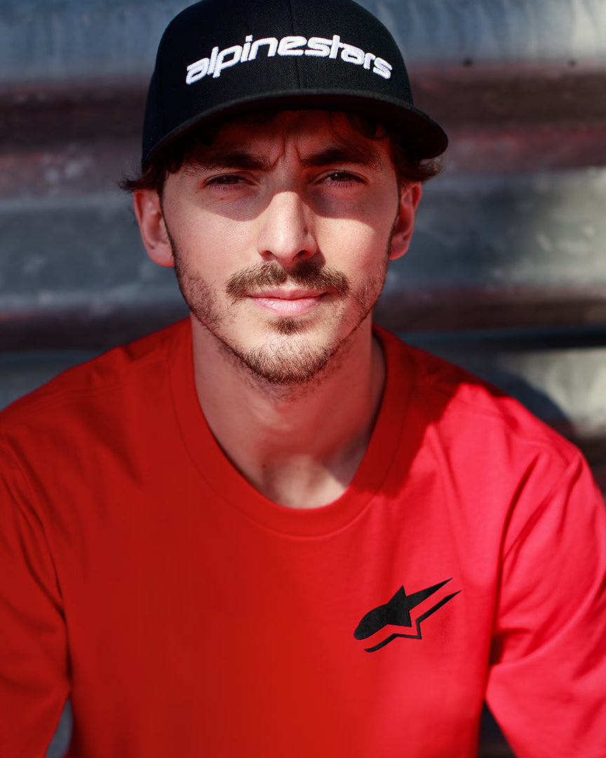 Alpinestars Formulate Csf Tee rossa, Francesco Bagnaia indossa una t-shirt a maniche corte con logo Astars nero e cappellino da baseball nero, streetwear casual a tema motorsport