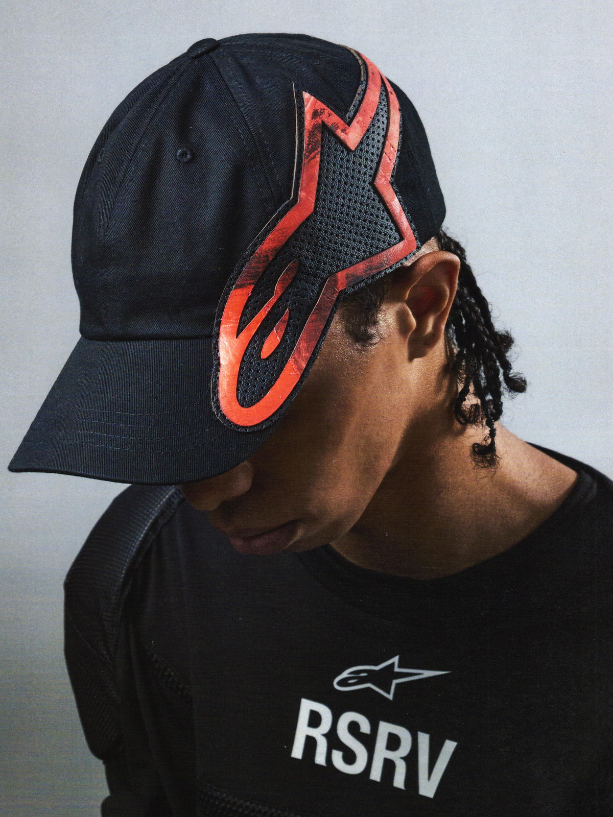 Alpinestars RSRV Lowside Hat, cappello nero con design fiammeggiante rosso e nero, streetwear premium, unisex