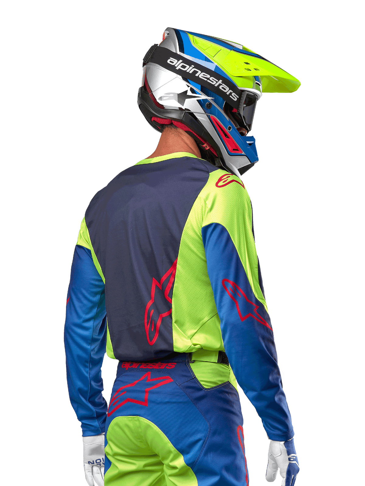 Pilota di motocross che indossa la maglia Alpinestars 2024 Racer Hoen in giallo fluo e blu night navy, con logo a stella rosso sulla schiena, pantaloni da motocross abbinati e casco da gara coordinato, vista posteriore che mette in risalto il design ergonomico per prestazioni fuoristrada.