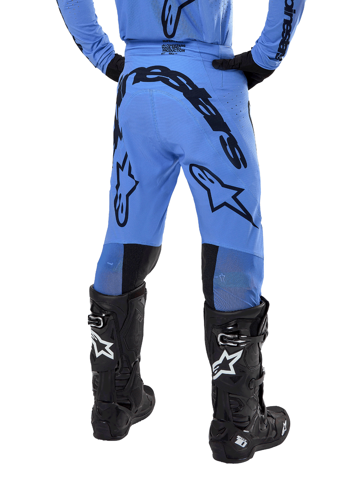 Pantaloni Alpinestars Supertech Dade 2024, pantaloni da motocross, blu chiaro, vista posteriore con grande marchio nero sulla seduta e sulle gambe, indossati con stivali neri Alpinestars Tech 10, vestibilità racing atletica per prestazioni professionali fuoristrada