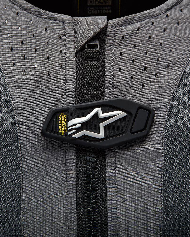 Dettaglio Alpinestars Tech-Air 5 Airbag, patta magnetica con logo a stella bianco su tessuto grigio traforato.