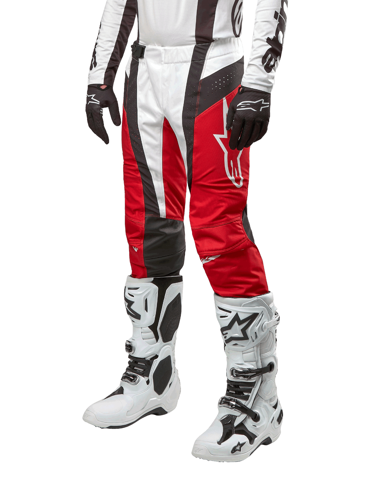 Alpinestars Pantaloni Techstar Ocuri 2024, pantaloni da motocross, Rosso Marte, bianco e nero, indossati con maglia coordinata bianca e nera, guanti neri e stivali da corsa bianchi con fibbie, abbigliamento protettivo tecnico mostrato su sfondo bianco