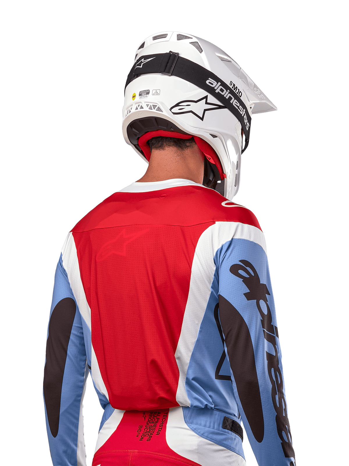 Alpinestars 2024 Techstar Ocuri Jersey, maglia da motocross, azzurro, rosso Marte e bianco, vista posteriore del pilota con casco bianco coordinato e occhiali neri, presenta un audace branding nero sulle maniche e vestibilità race ergonomica per prestazioni fuoristrada