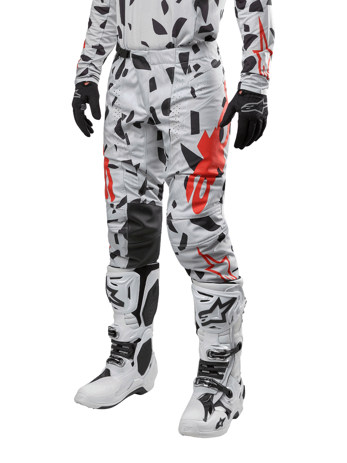 Alpinestars 2024 Techstar Rantera Pants, pantaloni da motocross, grigio Haze Gray Camo con motivo astratto nero e rosso, indossati con maglia coordinata, guanti neri e stivali da motocross bianchi, progettati per corse fuoristrada ad alte prestazioni