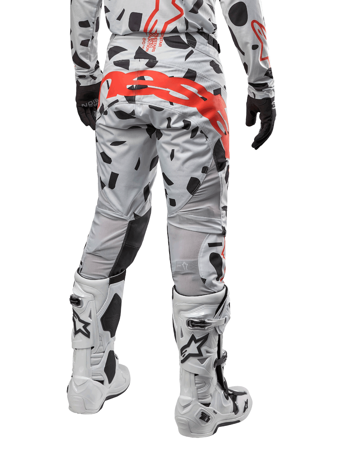 Alpinestars 2024 Techstar Rantera Pants, pantaloni da motocross, Haze Gray Camo con motivi mimetici neri e un grande logo Alpinestars rosso sulla seduta, vista posteriore indossata con stivali bianchi e abbigliamento da gara coordinato