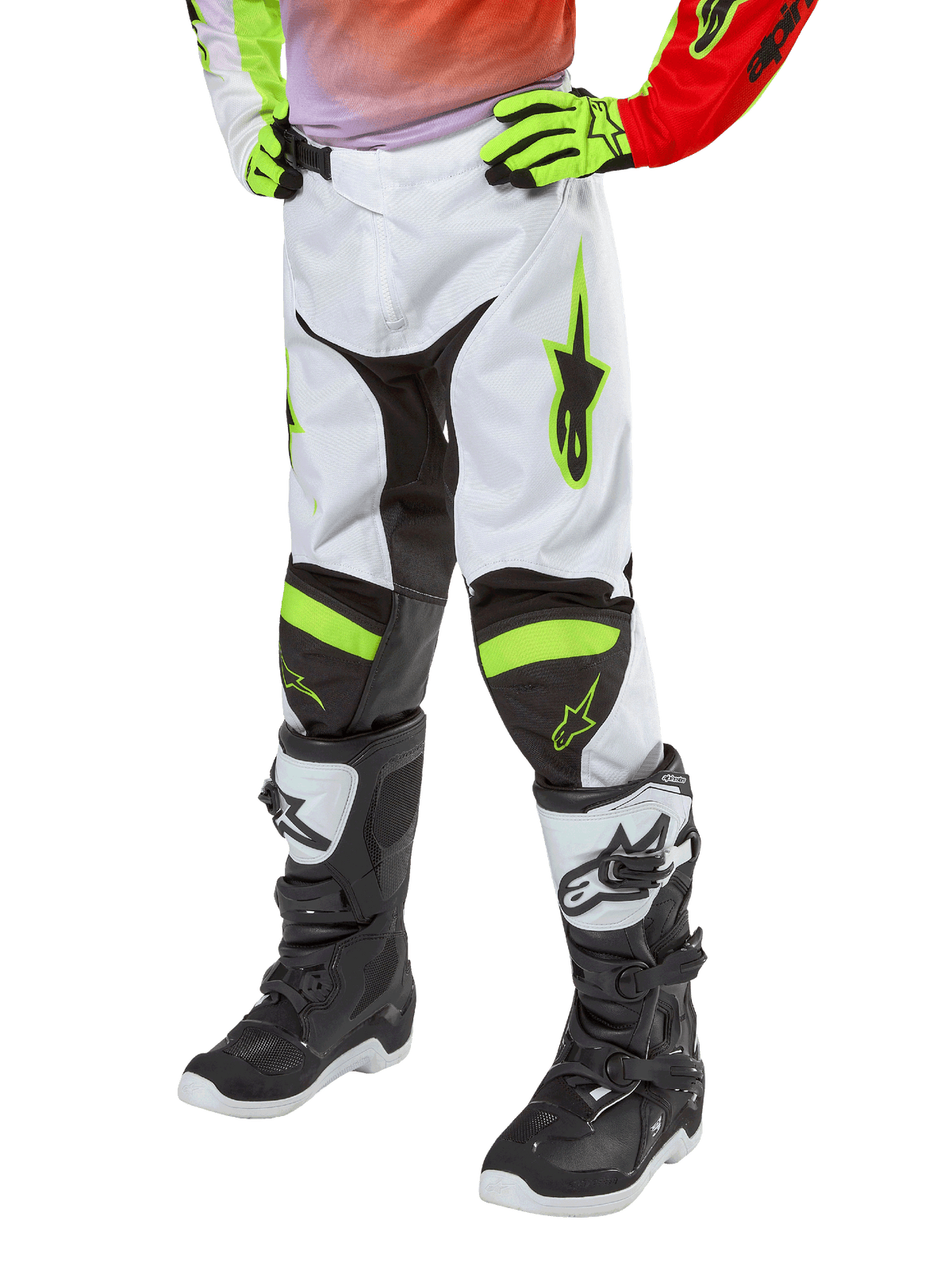 Alpinestars Youth 2024 Racer Lucent Pants, pantaloni da motocross, bianco, rosso neon e giallo fluo, vista della parte inferiore con pannelli elasticizzati neri e accenti neon, indossati con stivali da gara bianchi e neri e guanti giallo neon, abbigliamento tecnico da fuoristrada per ragazzi