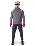 Alpinestars Giacca Antipioggia A-Dura, giacca da mountain bike, Grigio Dark Titanium con logo rosa, indossata con casco da MTB grigio e guanti rosa acceso, design protettivo con membrana a 2,5 strati per il ciclismo sotto la pioggia