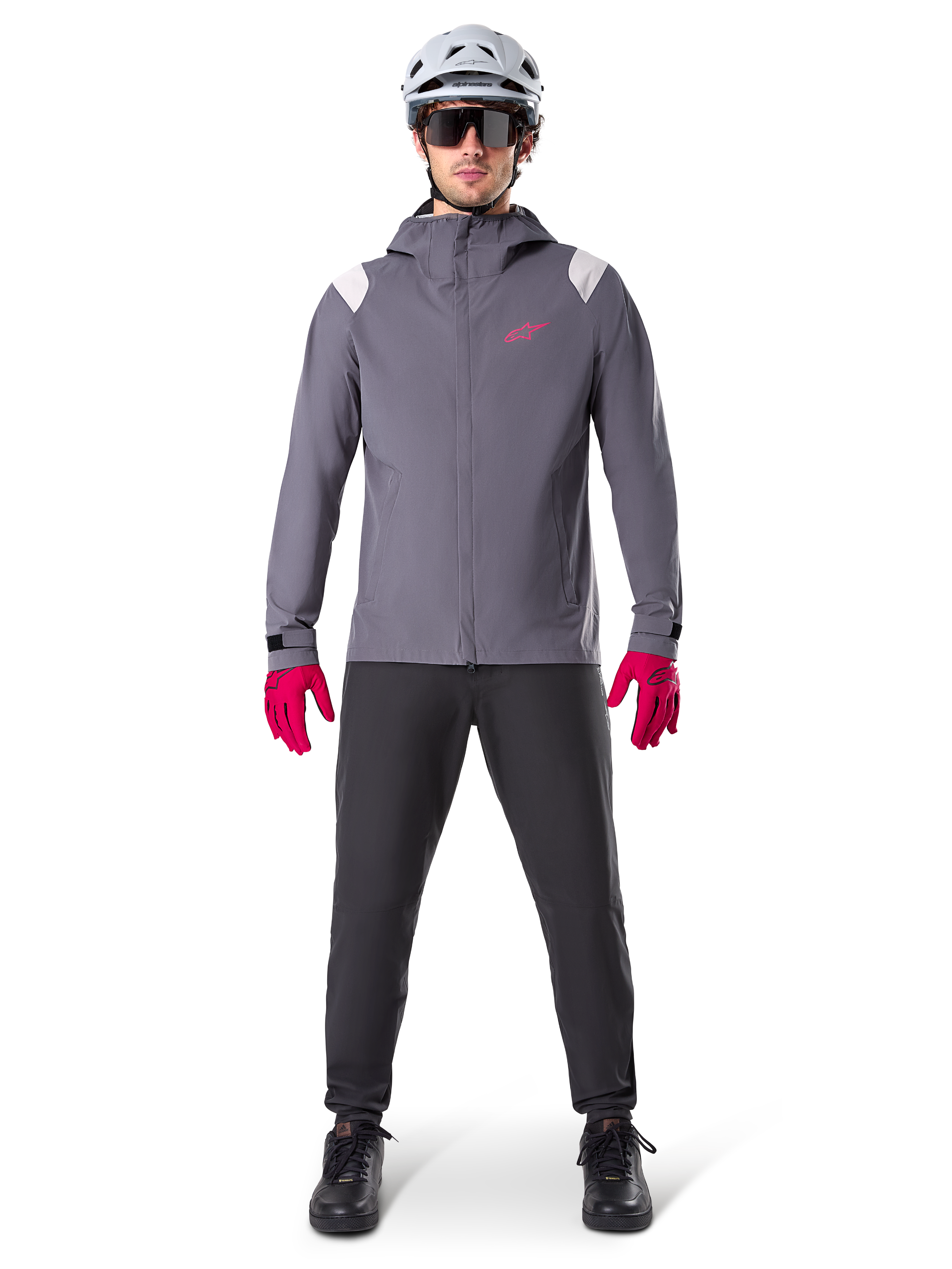 Alpinestars Giacca Antipioggia A-Dura, giacca da mountain bike, Grigio Dark Titanium con logo rosa, indossata con casco da MTB grigio e guanti rosa acceso, design protettivo con membrana a 2,5 strati per il ciclismo sotto la pioggia