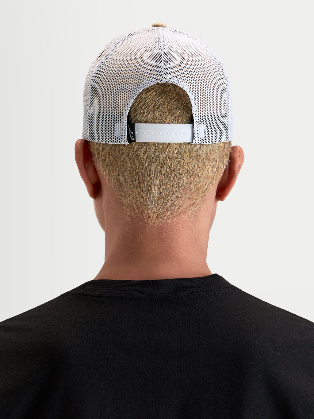 Alpinestars Cappello Cali 2.0, cappello trucker sportswear lifestyle unisex, color kaki e bianco, indossato e visto da dietro che mostra la chiusura snapback regolabile e la rete traspirante