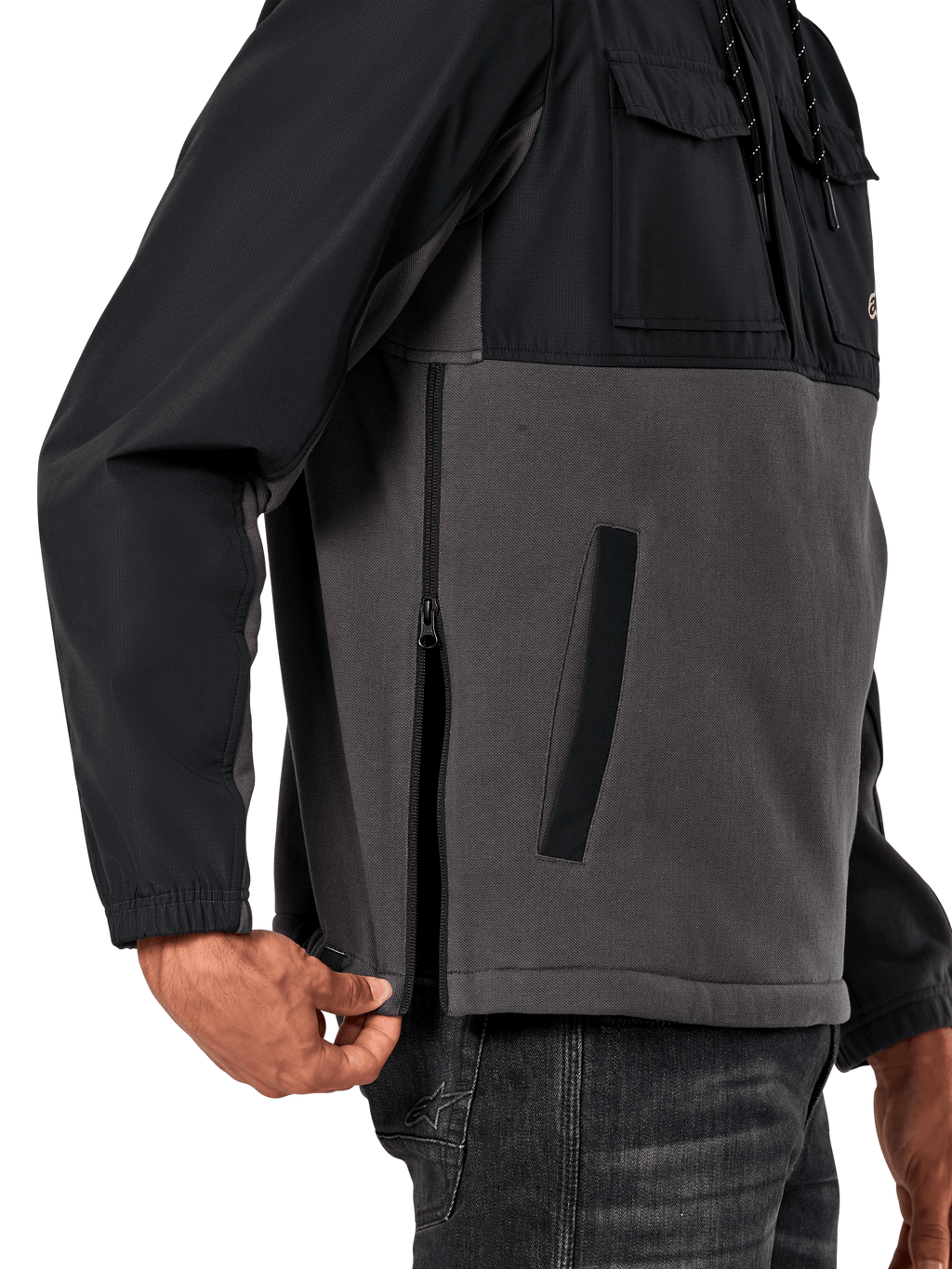 Giacca Alpinestars Juncture Hybrid in Black Gunmetal, vista laterale del dettaglio che evidenzia la cerniera laterale e la tasca inferiore a filetto, design in materiali misti con pile in tela grigia e sovrapposizioni in ripstop nero, streetwear casual ispirato al motorsport
