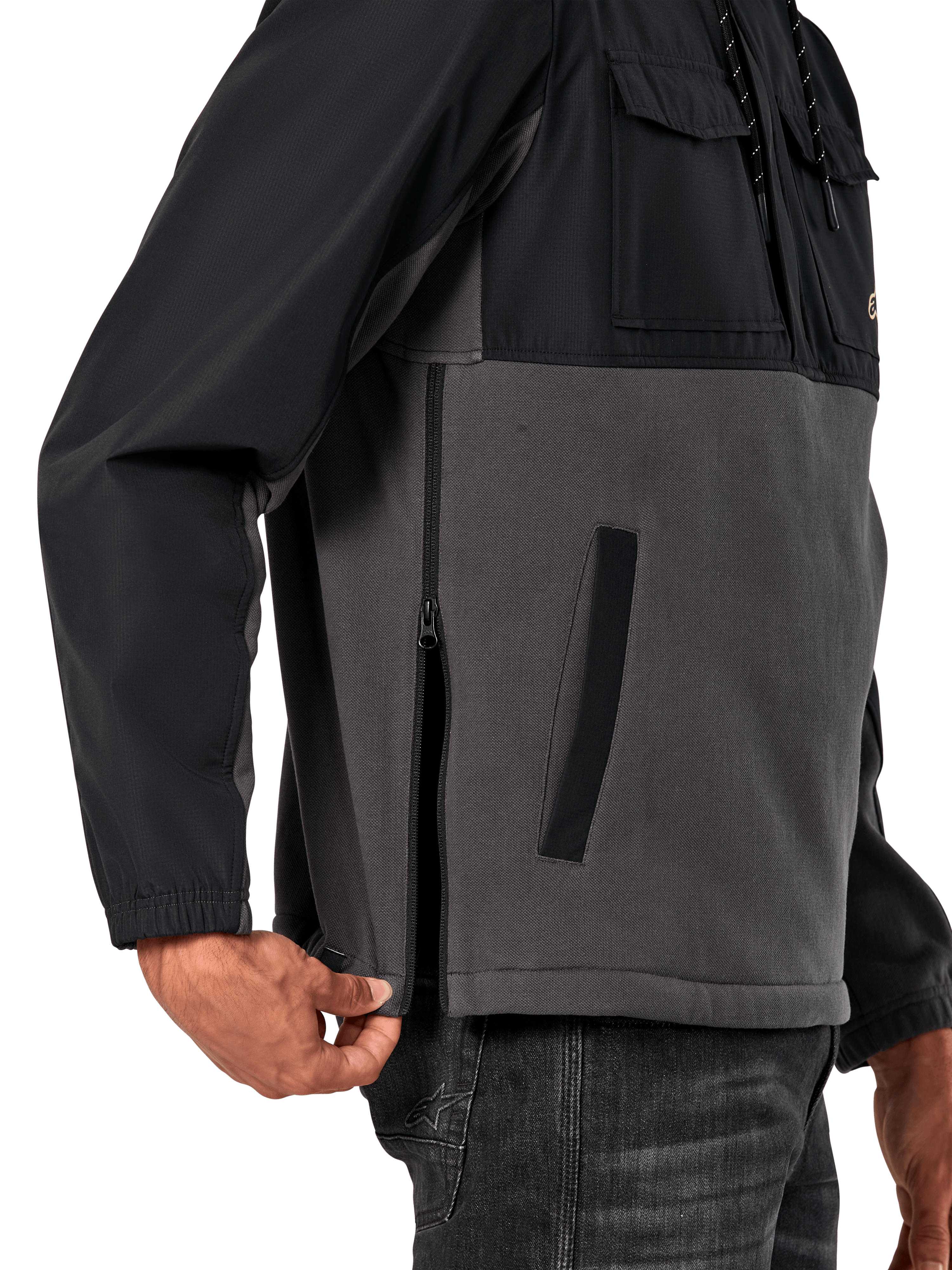 Giacca Alpinestars Juncture Hybrid in Black Gunmetal, vista laterale del dettaglio che evidenzia la cerniera laterale e la tasca inferiore a filetto, design in materiali misti con pile in tela grigia e sovrapposizioni in ripstop nero, streetwear casual ispirato al motorsport