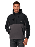 Alpinestars Juncture Hybrid Jacket, giacca anorak da uomo con cappuccio, nero e grigio gunmetal, design bicolore con inserti in ripstop e pile canvas, tasche sul petto con logo a stella bianco e cappuccio con coulisse, streetwear casual ispirato al motorsport