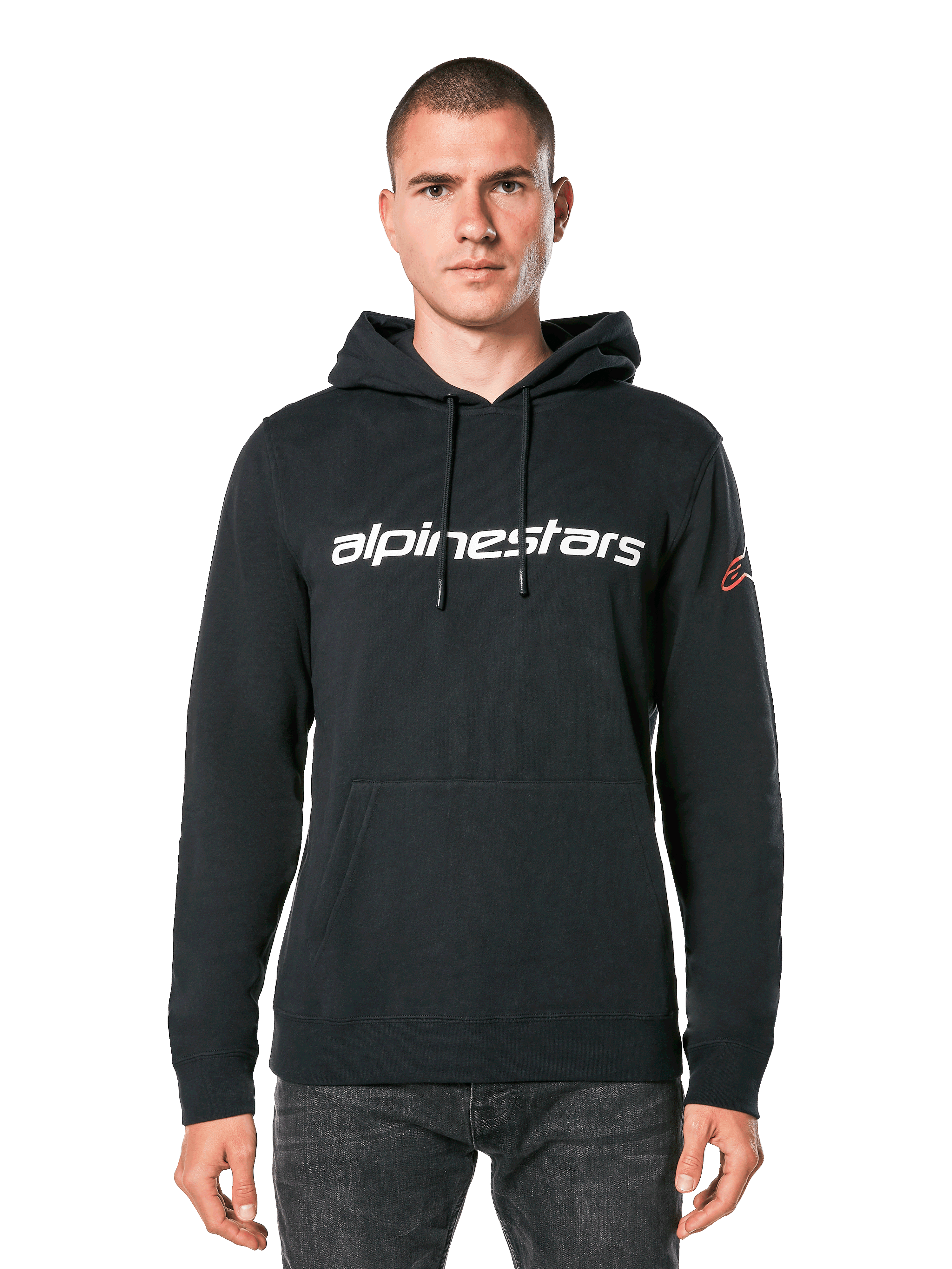Alpinestars Linear Wordmark V3 Hoodie, felpa nera con cappuccio, scritta Alpinestars bianca sul petto, logo Ageless rosso sulla manica, tasca a marsupio frontale, cappuccio con cordoncino, indossata da un modello, streetwear casual ispirato al motorsport