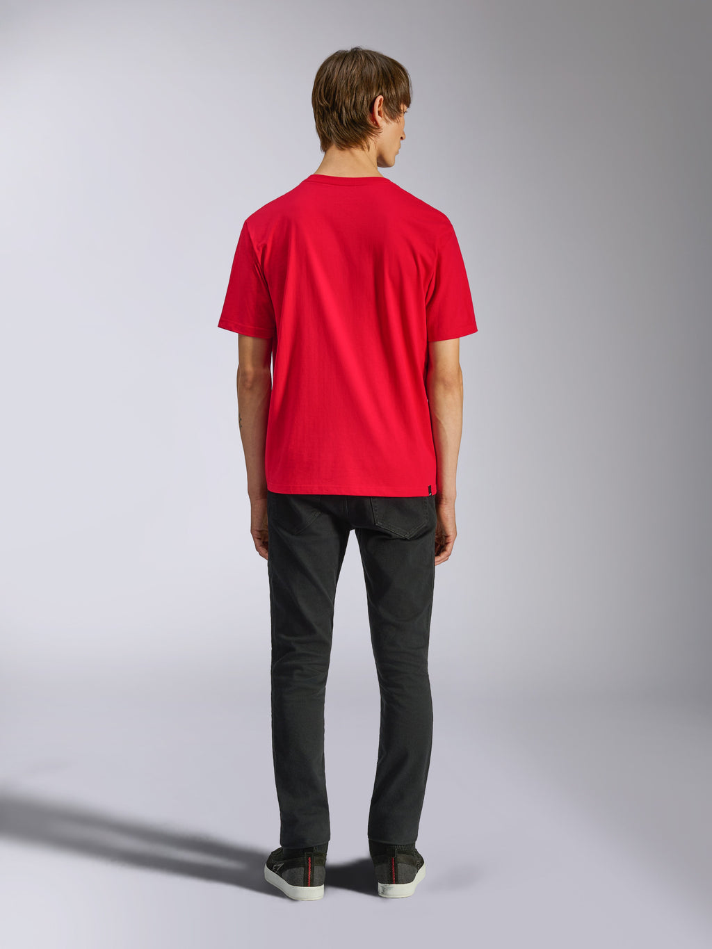 Alpinestars Ageless Shadow CSF Tee, maglietta a maniche corte, rosso, vista posteriore su modello abbinata a pantaloni neri, streetwear casual motorsport