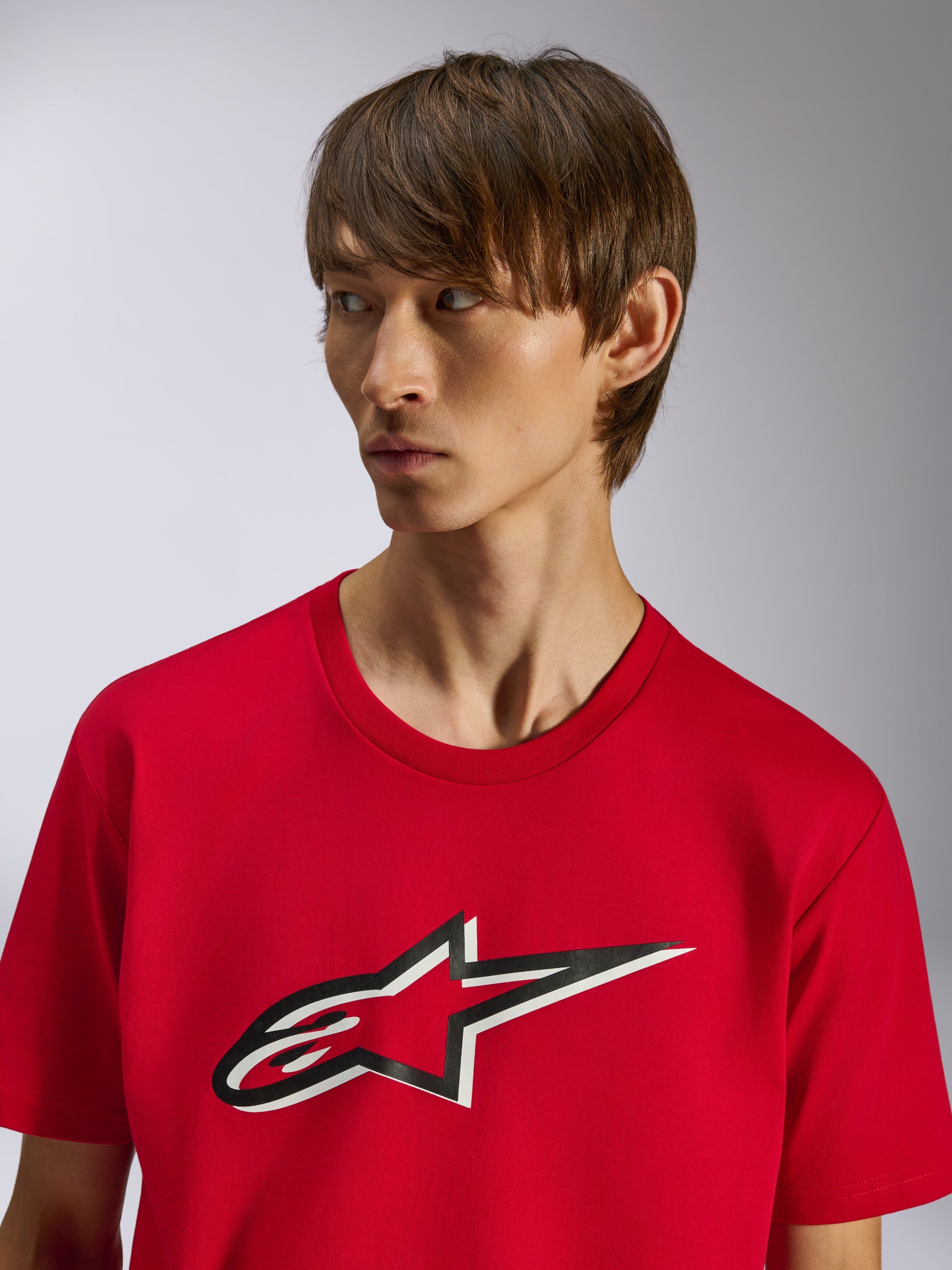 Alpinestars Ageless Shadow CSF Tee, t-shirt a maniche corte, rosso, logo frontale Ageless a stella con effetto ombra bianco e nero, indossata da un modello, design casual ispirato al motorsport