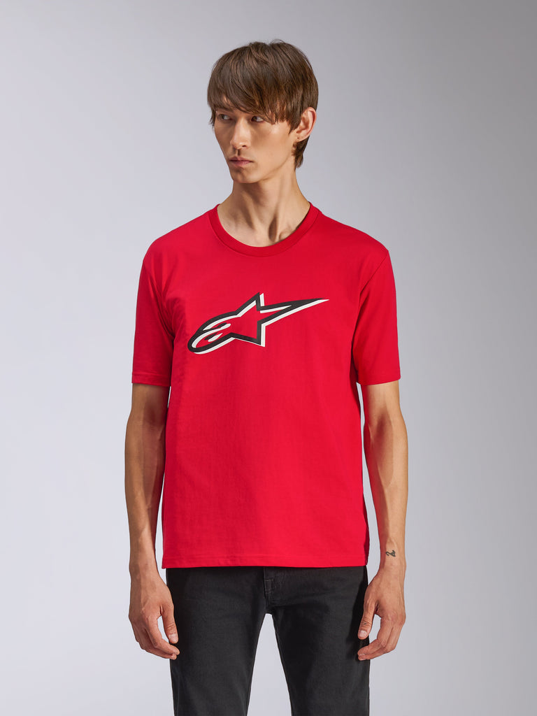 T-shirt Alpinestars Ageless Shadow CSF, maglietta rossa a maniche corte, con logo Ageless frontale con contorni bianchi e neri, indossata da un uomo con pantaloni neri, abbigliamento streetwear casual da motorsport