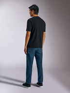 Alpinestars Ageless Shadow CSF Tee, maglietta a maniche corte, nero, vista posteriore, indossata con jeans blu e sneakers nere, streetwear casual ispirato al motorsport