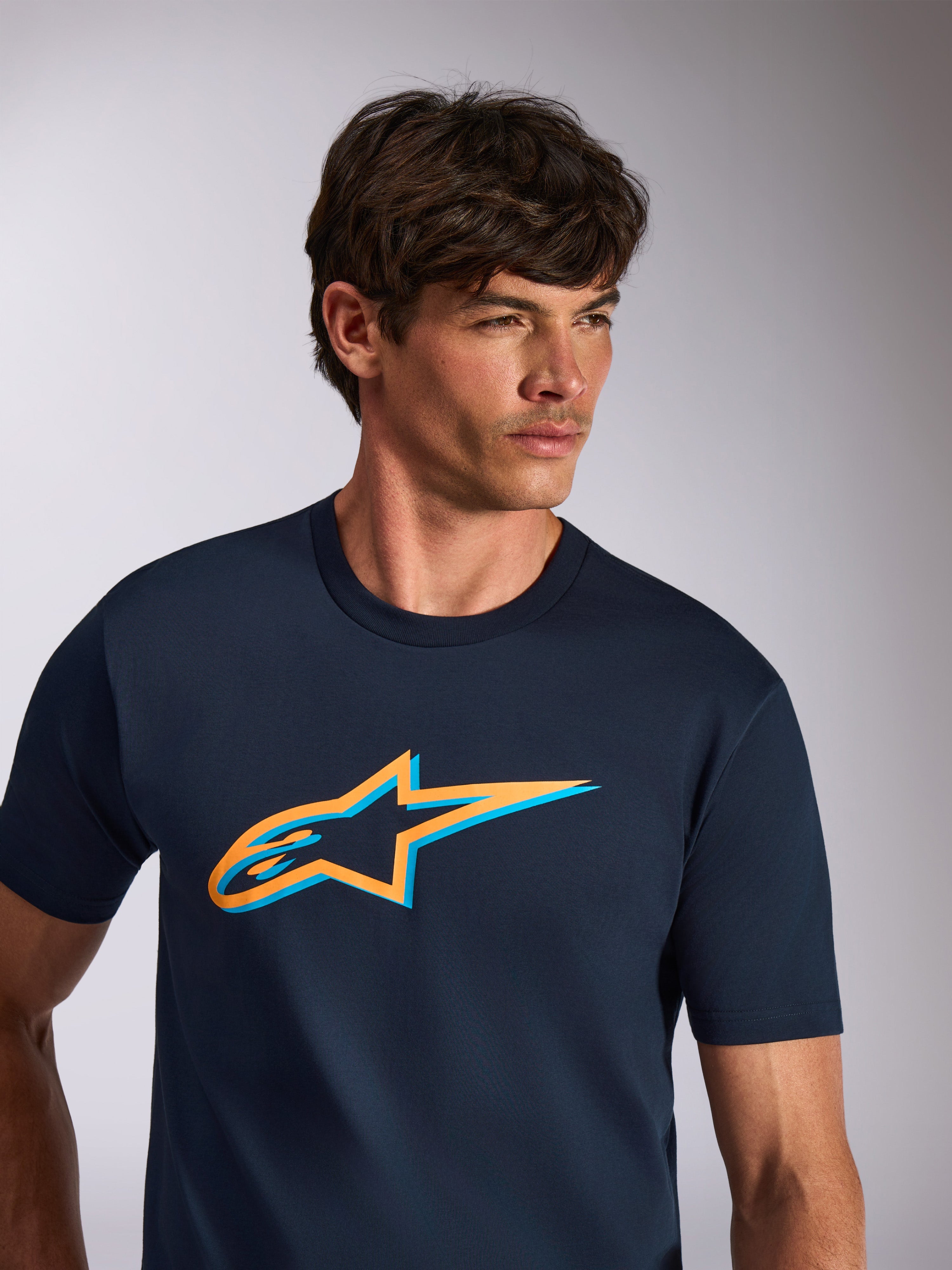 Alpinestars Ageless Shadow CSF Tee, t-shirt a maniche corte, blu navy con logo Astars arancione e azzurro, abbigliamento casual streetwear ispirato al motorsport
