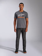 Alpinestars Always 2.0 CSF Tee, maglietta a maniche corte, grigio antracite con logo bianco e testo arancione, indossata da un modello con jeans scuri, streetwear casual motorsport