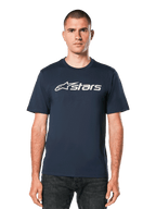 Alpinestars Blaze 2.0 CSF Tee, t-shirt a maniche corte blu navy con grafica logo Astars bianco, indossata da un uomo con jeans scuri, abbigliamento lifestyle motorsport casual