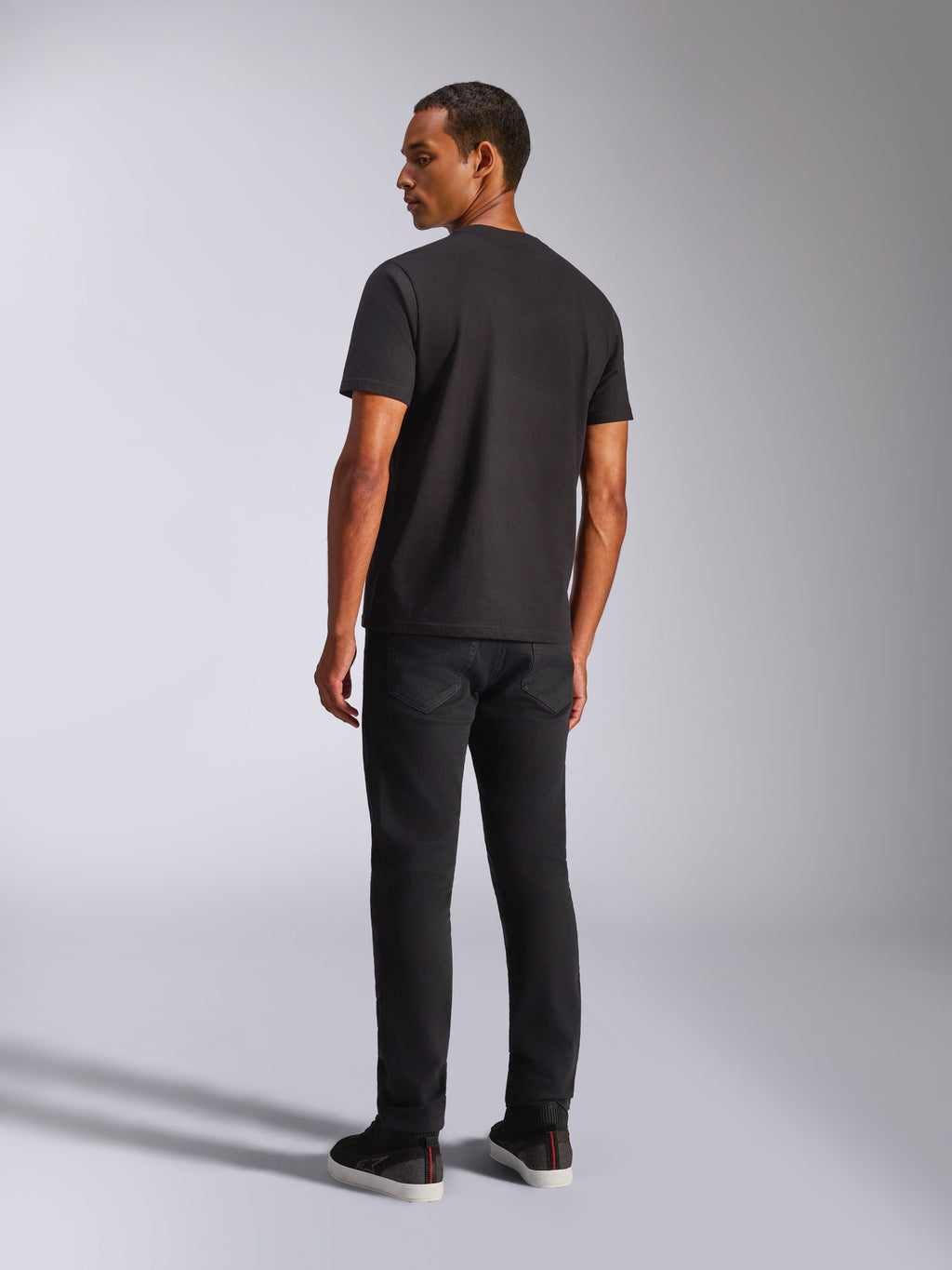 Alpinestars Blaze 2.0 CSF Tee, maglietta a maniche corte, nero, vista posteriore su modello, indossata con pantaloni neri, streetwear casual motorsport
