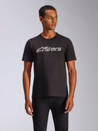 Alpinestars Blaze 2.0 CSF Tee, maglietta a maniche corte nera indossata da un modello, logo Alpinestars grigio e bianco sul petto, streetwear casual ispirato al motorsport