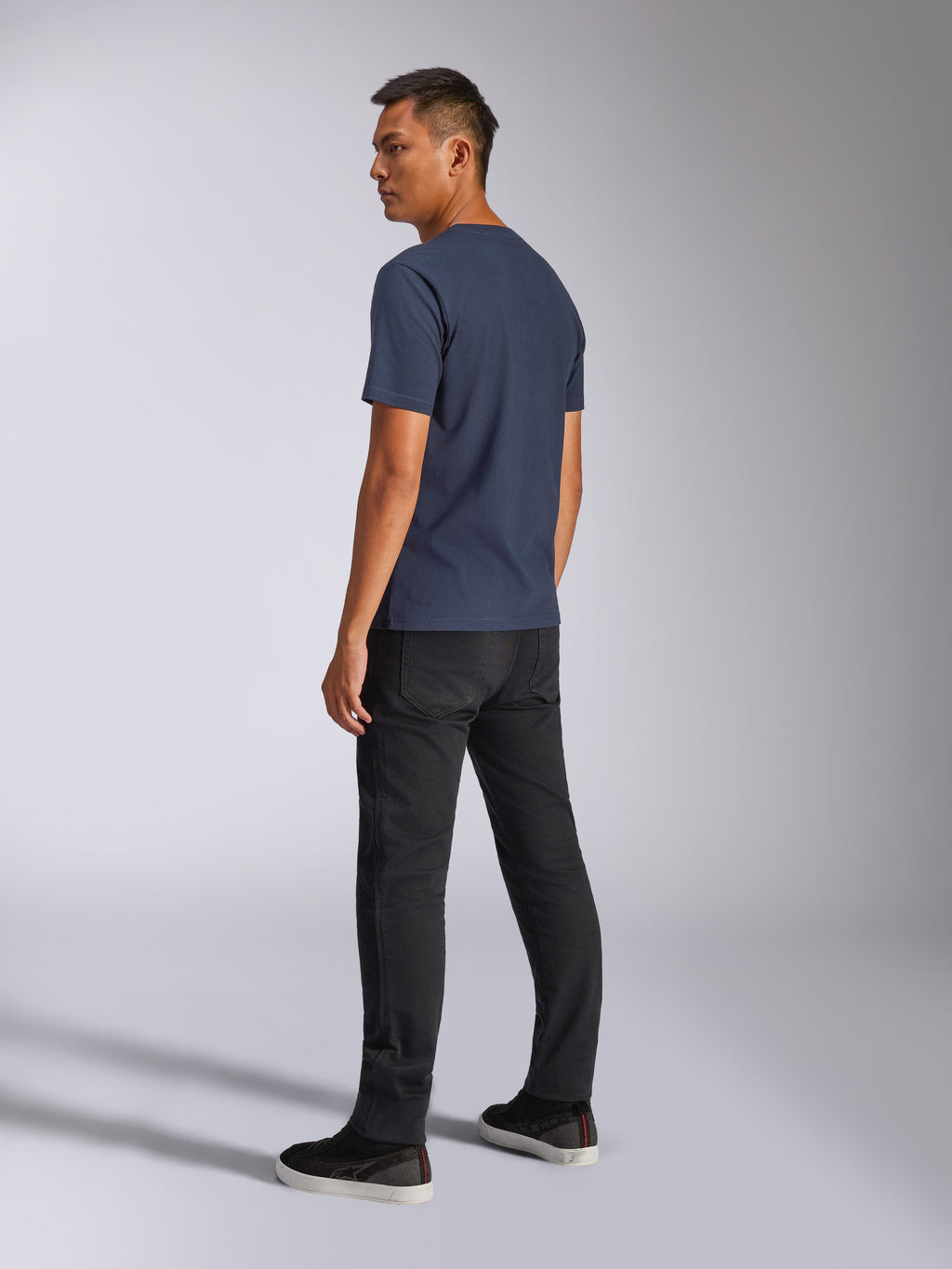 Alpinestars Blaze 2.0 CSF Tee, maglietta a maniche corte, blu navy, vista posteriore su modello, abbinata a pantaloni neri e sneakers, streetwear casual ispirato al motorsport