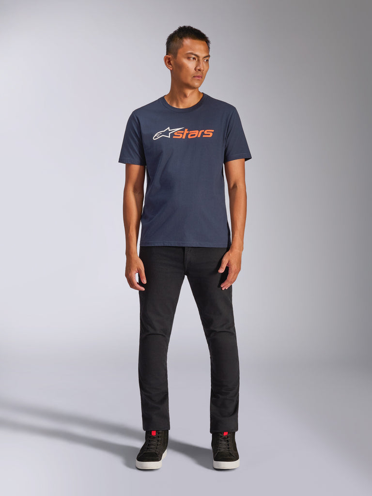 Alpinestars Blaze 2.0 CSF Tee, maglietta a maniche corte, blu navy con logo Astars bianco e arancione, indossata con pantaloni neri e sneakers nere, streetwear casual ispirato al motorsport