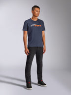 Alpinestars Blaze 2.0 CSF Tee, maglietta a maniche corte, blu navy con logo Blaze bianco e arancione, indossata da un modello con pantaloni neri e sneakers, streetwear casual ispirato al motorsport