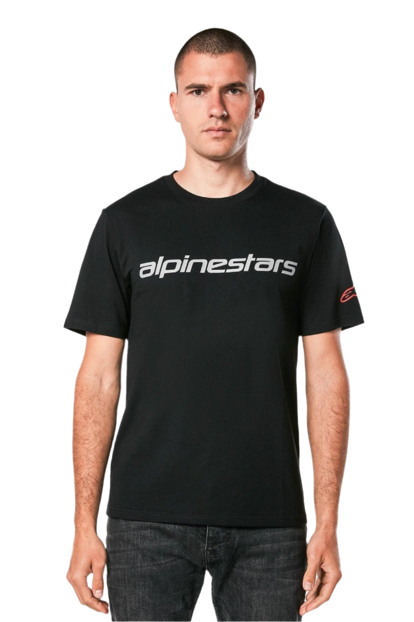 Alpinestars Linear Wordmark 2.0 CSF Tee, maglietta a maniche corte, nero, marchio lineare grigio sul petto e logo Ageless rosso sulla manica, indossata da un modello con jeans scuri, streetwear casual ispirato al motorsport