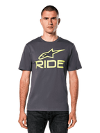 Alpinestars Ride 4.0 CSF Tee, maglietta a maniche corte, grigio scuro con logo Astars e scritta Ride in giallo lime, streetwear casual motorsport, indossata da un modello con jeans scuri su sfondo bianco