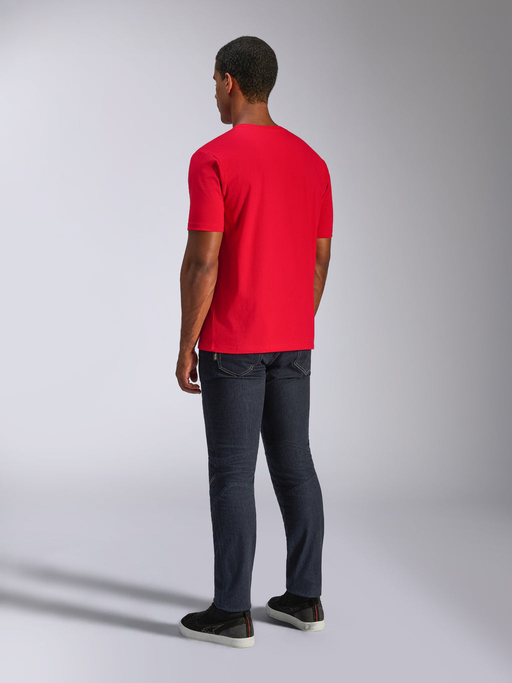 Alpinestars CSF Tee, t-shirt a maniche corte, rosso, vista posteriore su modello, indossata con jeans scuri e scarpe nere, streetwear casual ispirato al motorsport