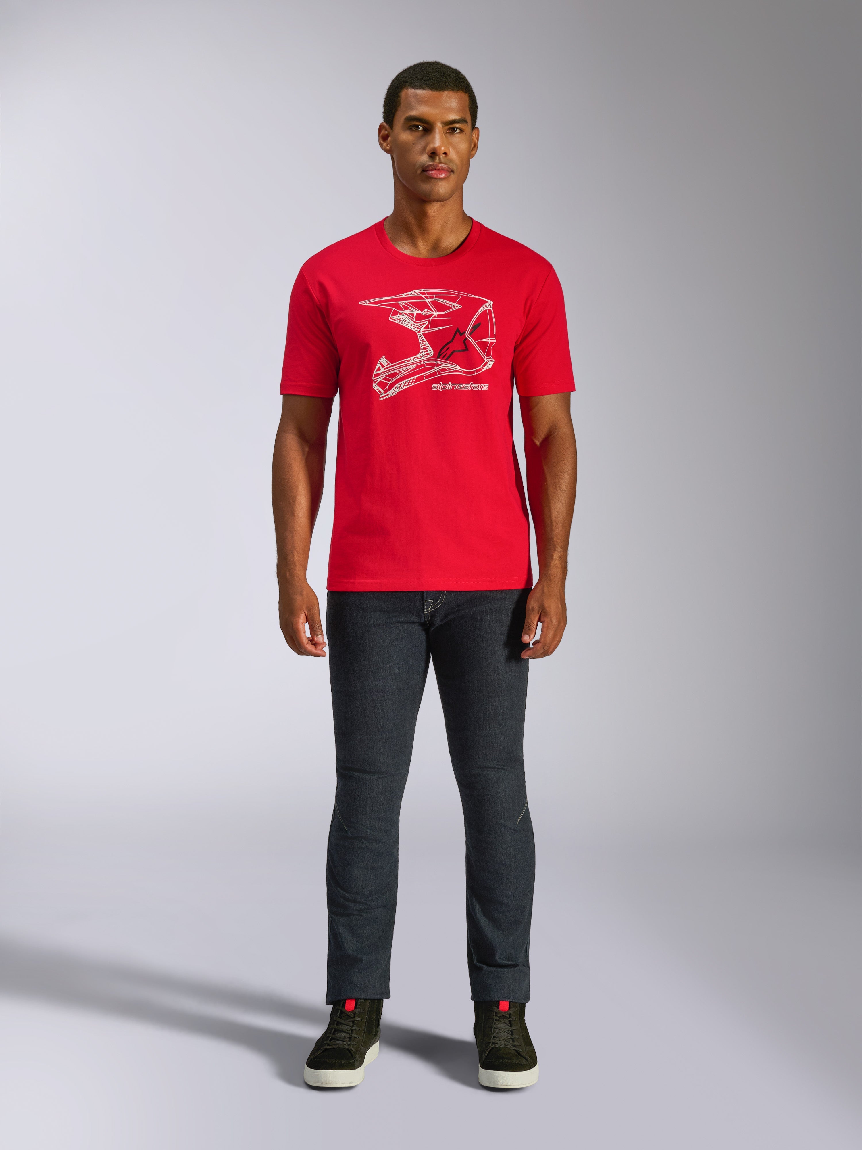 Alpinestars MX Helmet CSF Tee, t-shirt a maniche corte, rosso, grafica bianca con casco MX, abbigliamento sportivo casual da motorsport, indossata con jeans scuri e sneakers