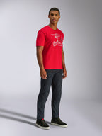 T-shirt Alpinestars CSF, maglietta a maniche corte, rossa, grafica bianca con casco MX, indossata da un modello con jeans in denim scuro e sneaker nere, abbigliamento casual motorsport streetwear