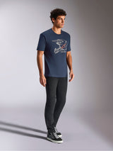 Alpinestars MX Helmet CSF Tee, t-shirt a maniche corte, blu navy, con grafica lineare bianca di un casco da motocross e logo a stella rosso, streetwear casual ispirato al motorsport indossato con pantaloni neri e sneaker alte