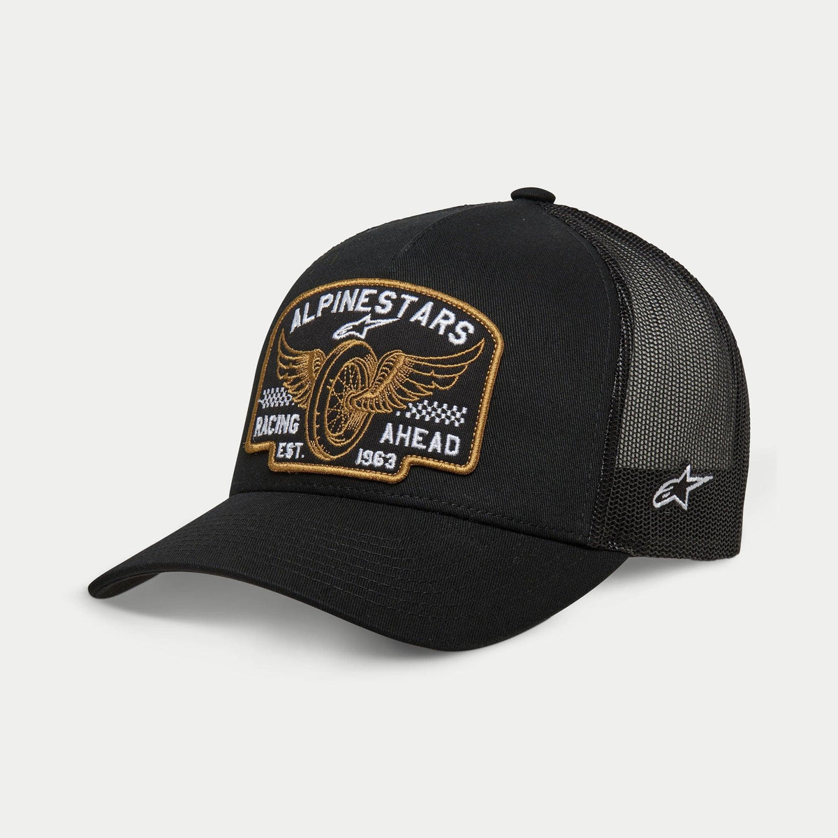 Alpinestars Heritage Patch Trucker Hat, nero, corona strutturata con visiera curva, grande patch frontale ricamata heritage con ruota alata e 'Racing Ahead Est. 1963', pannelli posteriori in rete nera con logo a stella laterale, copricapo casual motorsport lifestyle