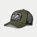 Cappello Alpinestars Heritage Patch Trucker, nero militare e verde oliva, visiera curva con corona strutturata, grande patch ricamata frontale con grafica di ruota di moto vintage e scritta 'Racing Ahead', retro in rete nera con logo Ageless bianco sul lato.