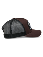 Alpinestars Heritage Patch Trucker Hat, marrone e nero, con corona strutturata e grande patch ricamata, visiera curva e retro in rete nera, design casual ispirato al motorsport