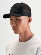 Alpinestars Cappello Heritage Patch, cappellino trucker sportswear casual, nero e grigio, con visiera curva e corona strutturata con patch logo ricamata sul davanti, indossato da un modello