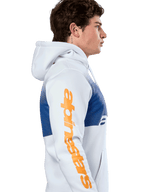 Alpinestars Specter Hoodie, streetwear casual, bianca con stampa a sfumatura blu, grande logo Alpinestars arancione sulla manica, profilo laterale di un uomo che indossa la felpa con cappuccio