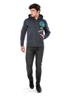 Alpinestars Variegate Hoodie, felpa in pile con zip frontale, grigio Gunmetal, indossata da un modello con jeans neri e sneakers, con marchio 'ASTARS' verde acqua e grafiche logo colorate su maniche e petto, streetwear casual ispirato al motorsport