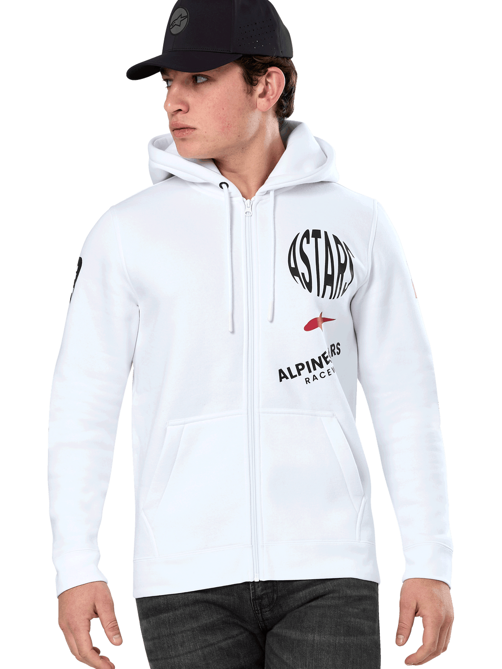 Alpinestars Variegate Hoodie, felpa bianca con cappuccio e zip con grafiche racing ASTARS nere e rosse, indossata da un modello con cappellino nero e jeans scuri, abbigliamento streetwear motorsport casual con tasca a marsupio e cappuccio con cordino